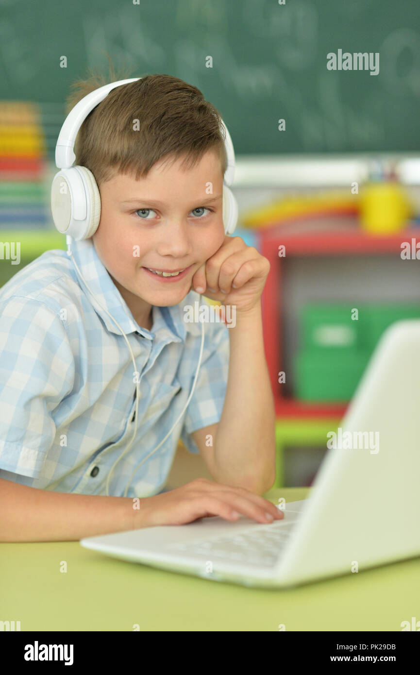 boy with headphones using laptop in classroom Stock Photo - Alamy