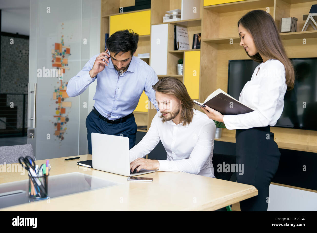 Three young business people at the meeting discussing ideas in the ...
