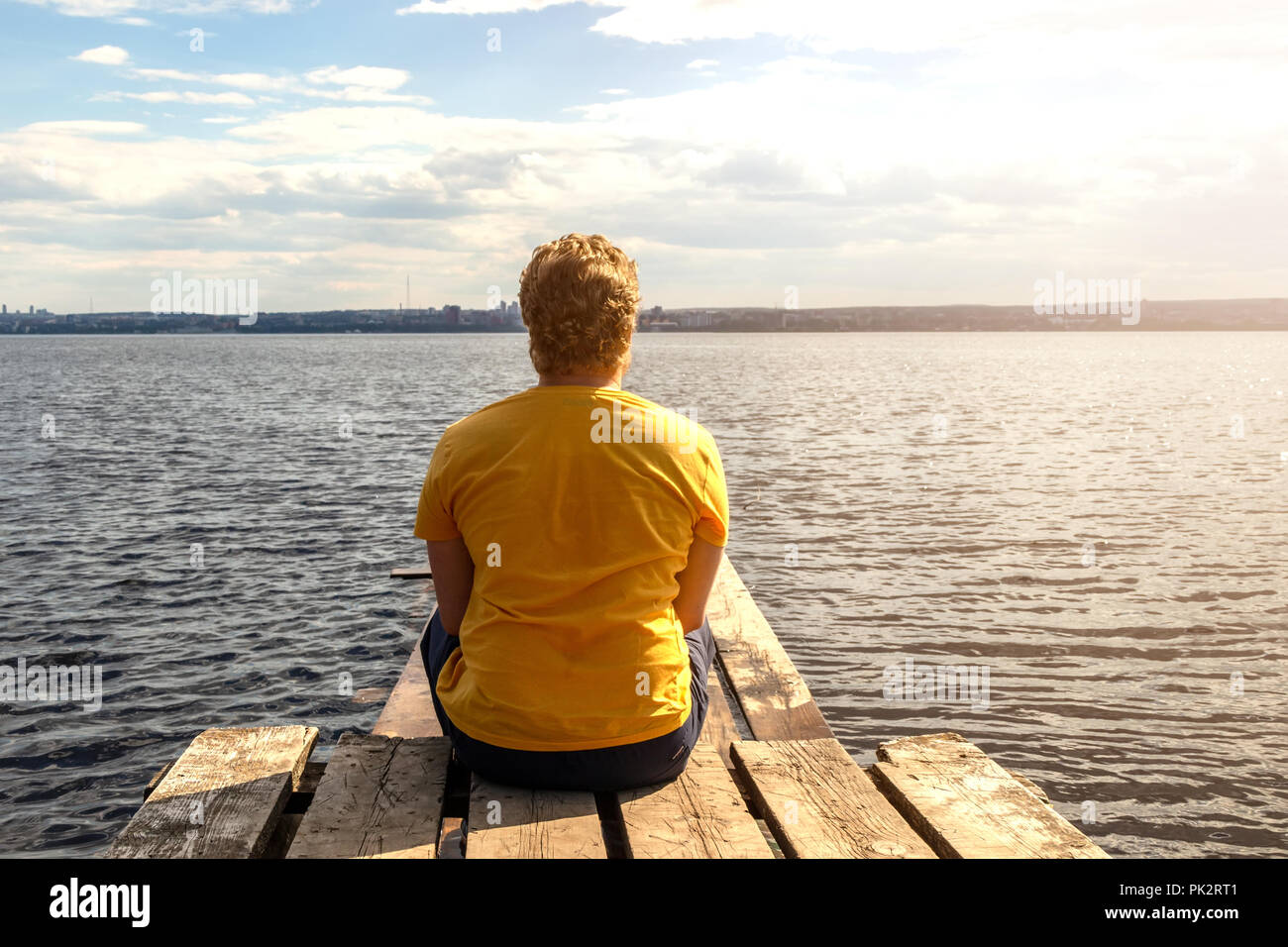 Sad lonely young man sits hi-res stock photography and images - Alamy