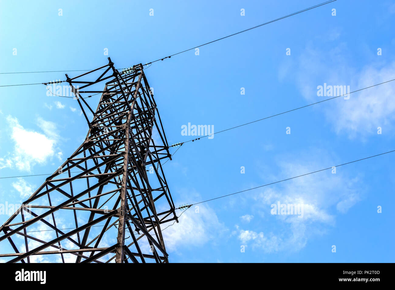 Power line support against blue sky background Stock Photo - Alamy