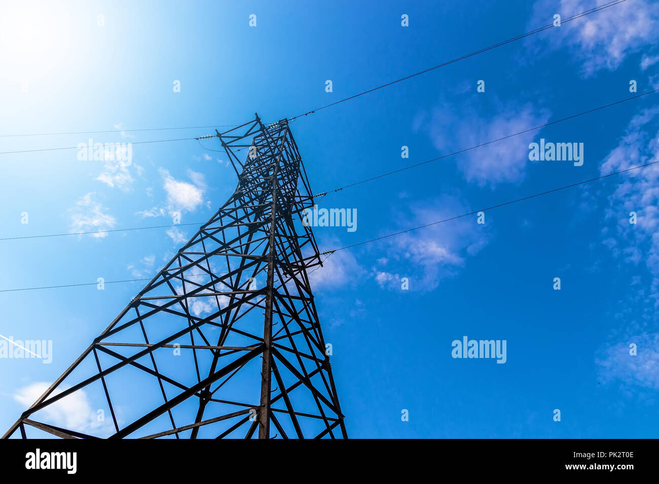 Power line support against blue sky background Stock Photo - Alamy