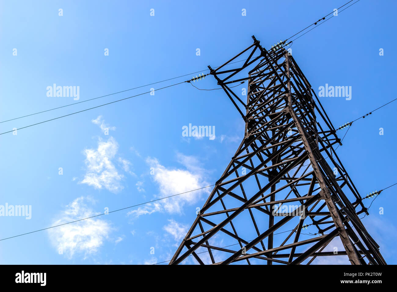 Power line support against blue sky background Stock Photo - Alamy
