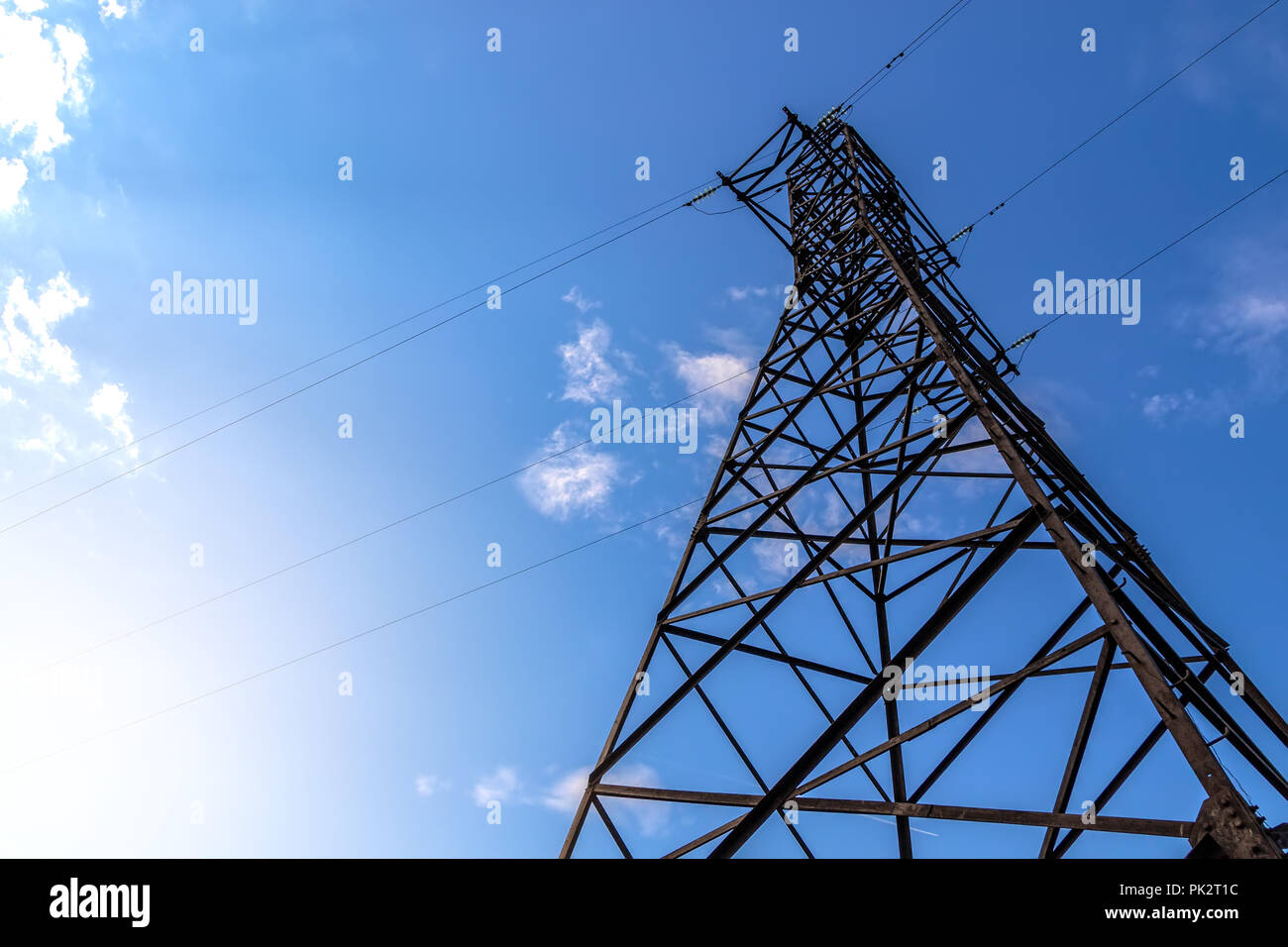Power line support against blue sky background Stock Photo - Alamy