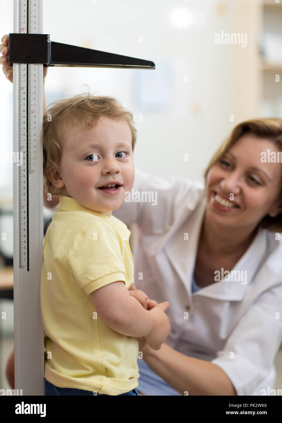Female doctor measuring height of little boy in clinic Stock Photo