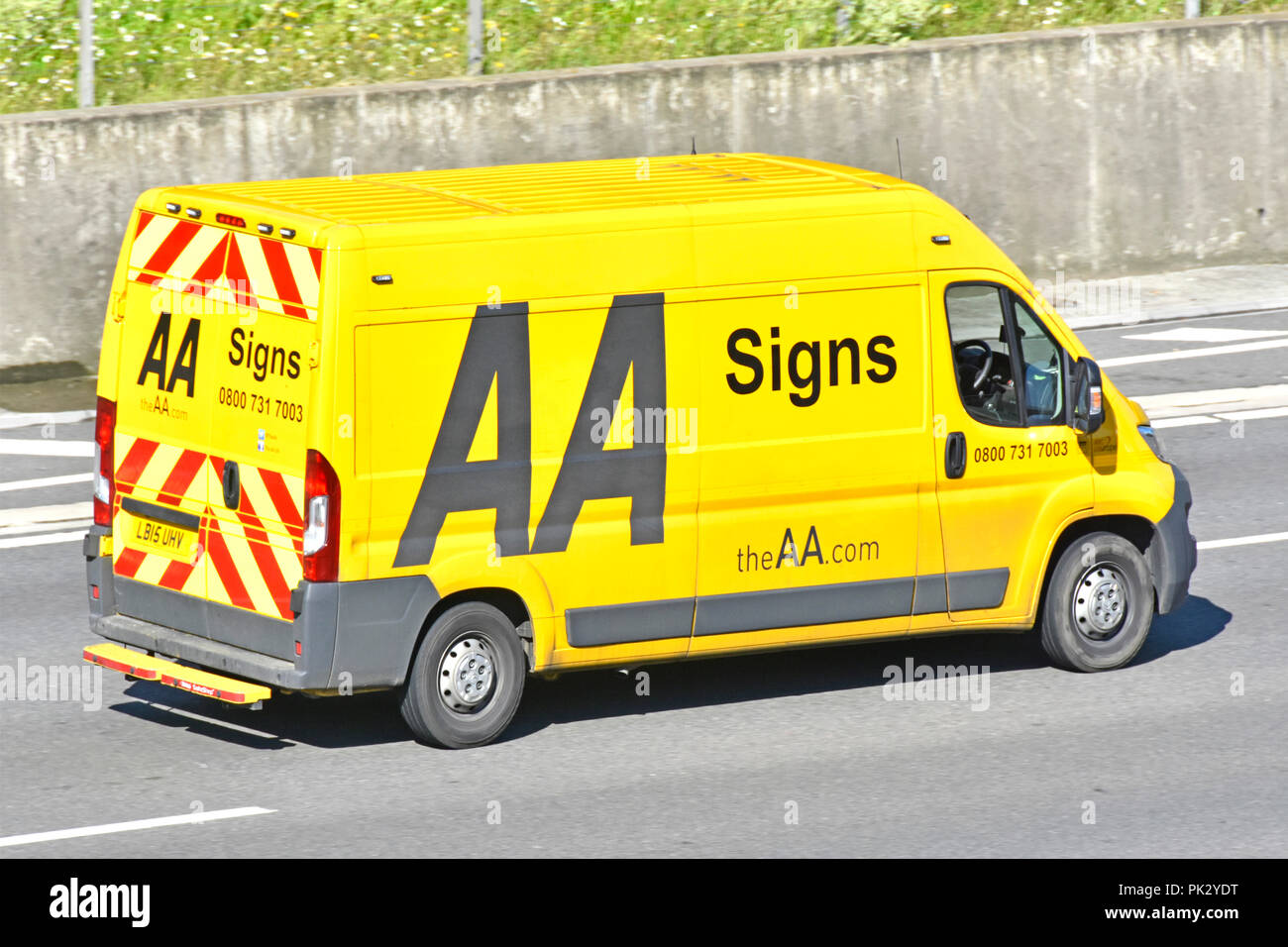 AA Automobile Association yellow van driving on UK motorway that deals with erection dismantling of temporary road & event signs to assist motorists Stock Photo