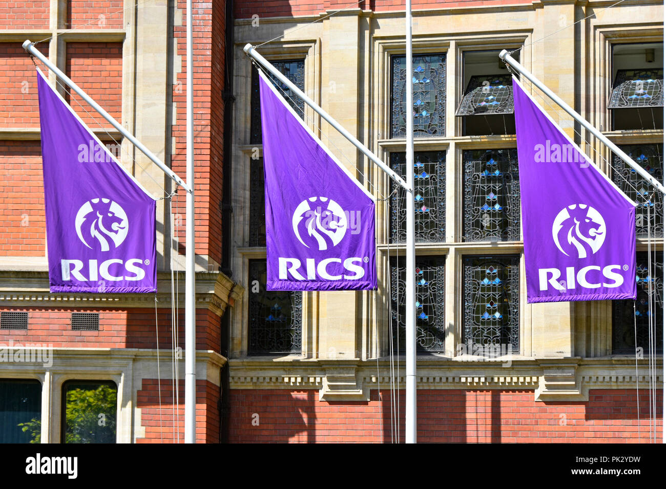 Close up of Royal Institution of Chartered Surveyors RICS logo on flags outside institute headquarters building Parliament Square London England UK Stock Photo