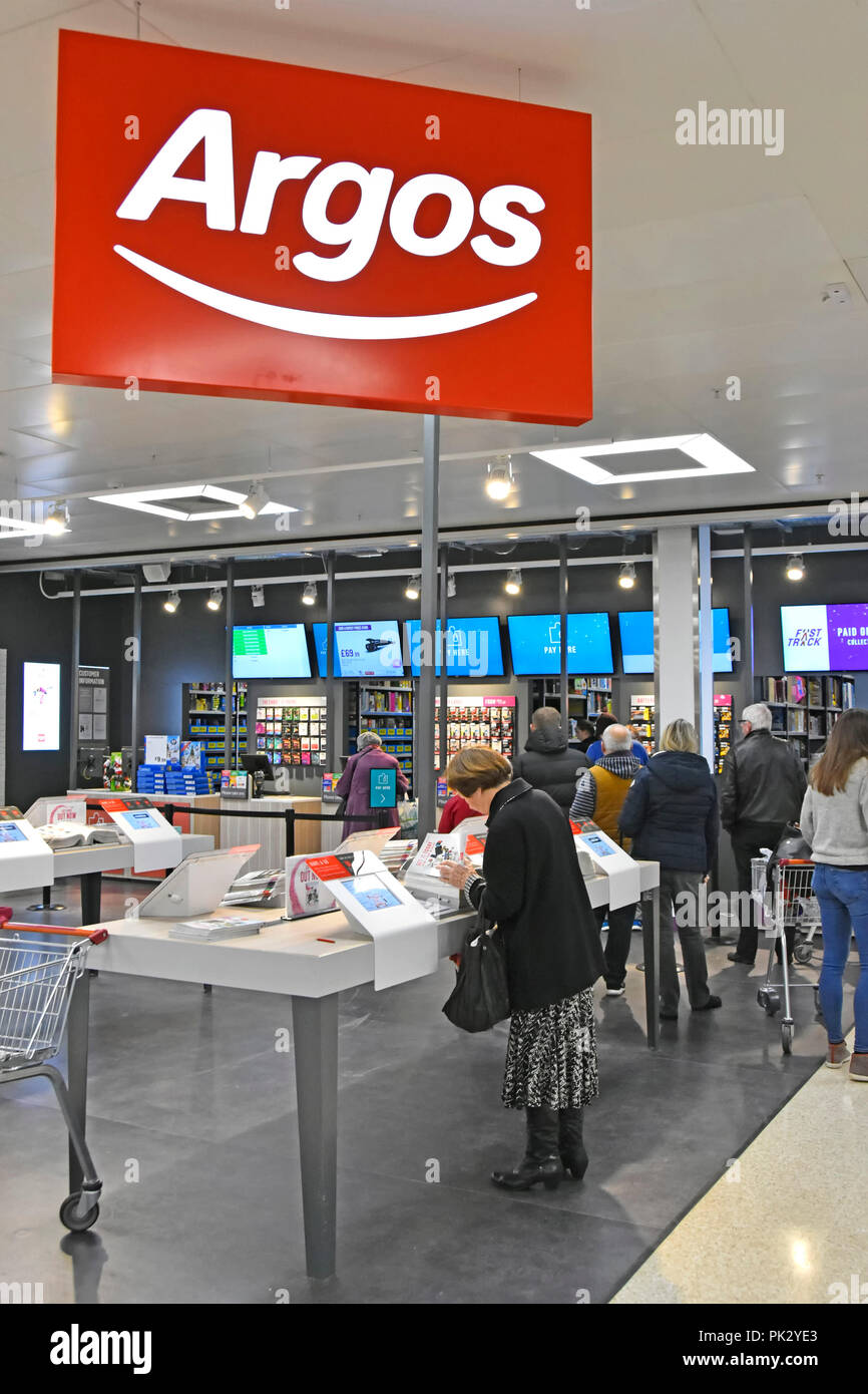 Shopping customers in new Argos catalogue shop inside a Sainsburys supermarket store replacing & closing down local high street premises England UK Stock Photo