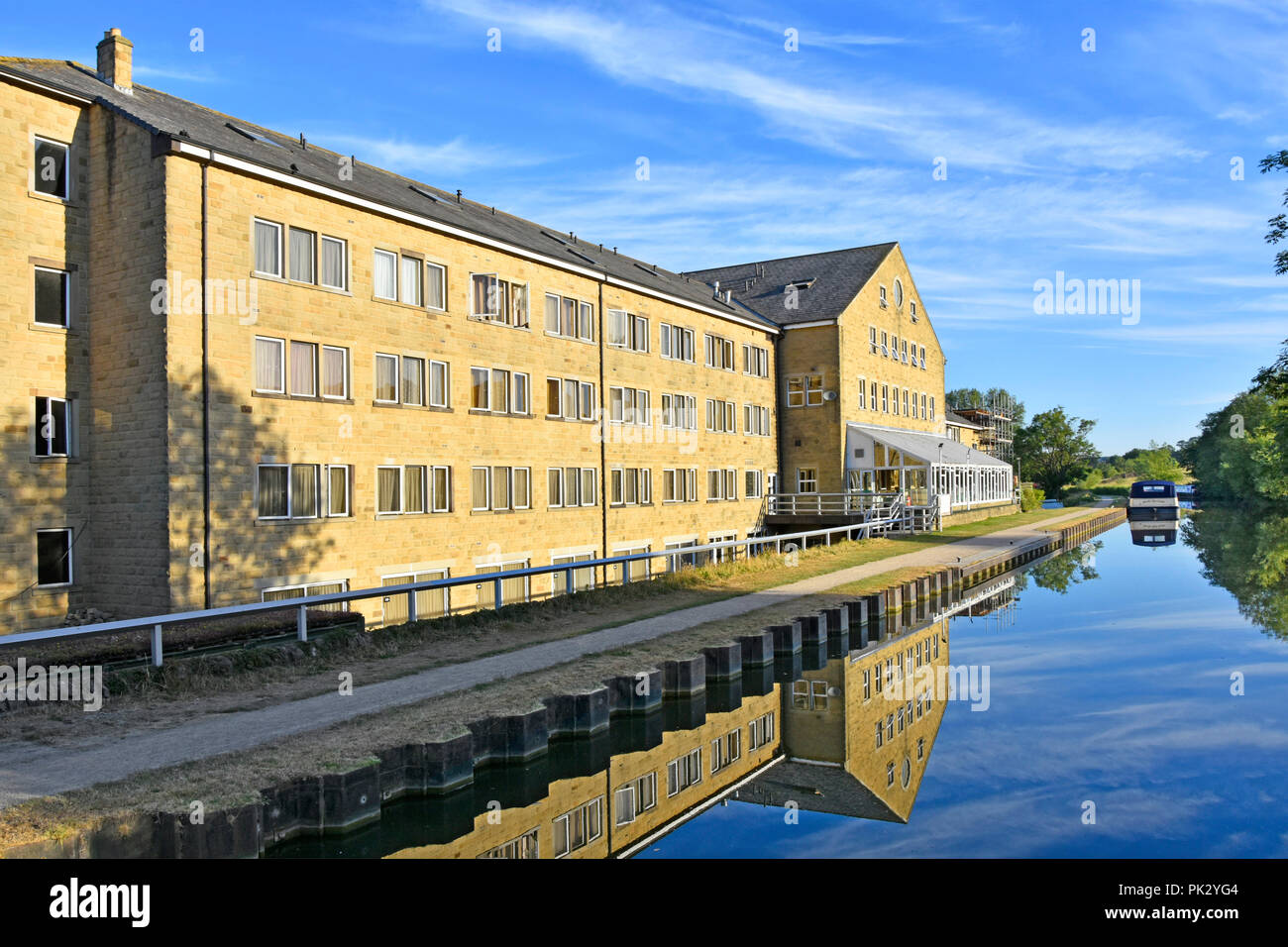 Rendezvous Hotel & restaurant conservatory reflection in still water of Leeds Liverpool Canal Skipton Gateway to the Dales North Yorkshire England UK Stock Photo