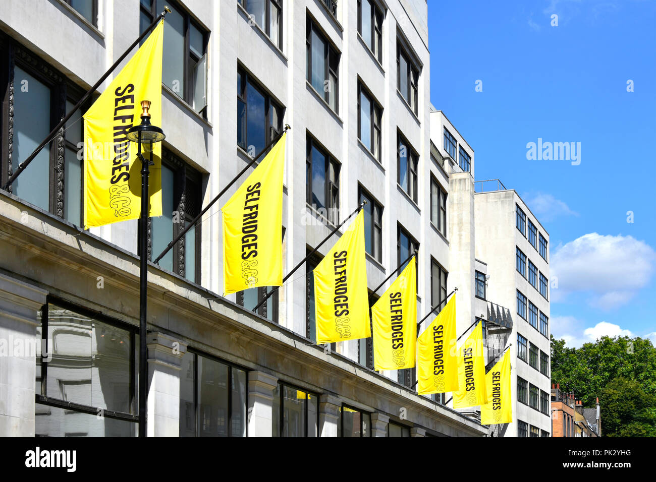 London shopping street yellow banner above Duke Street annex building behind the famous Selfridges retail department store in Oxford Street England UK Stock Photo