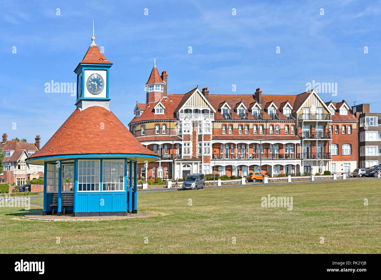Was Grand Hotel now Grand Apartments  victorian building &  modern clock tower shelter on greensward holiday seaside resort  Frinton on Sea Essex UK Stock Photo