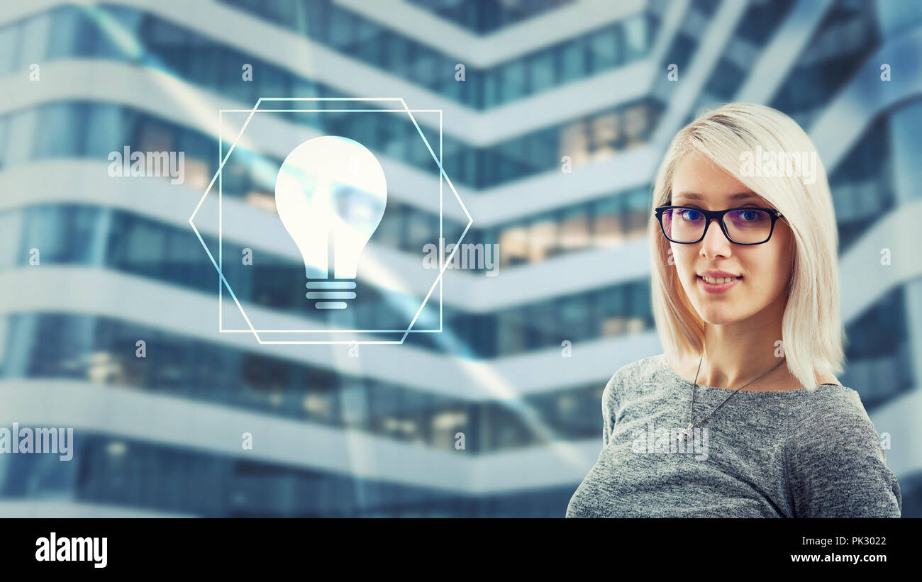 Beautiful woman wearing eyeglasses looking at camera having idea as light bulb icon glow on digital screen interface. Creativity artificial intelligen Stock Photo