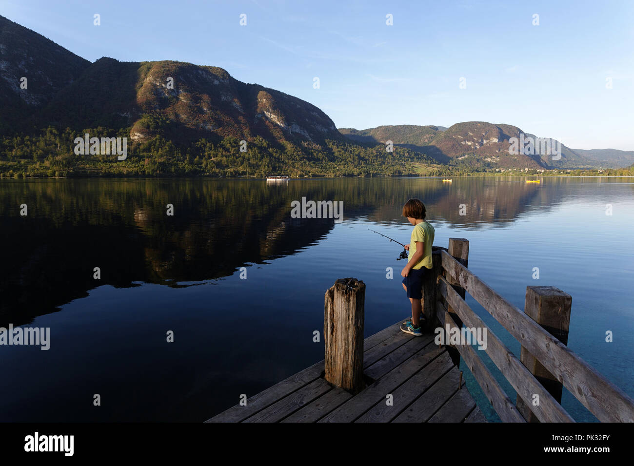 Young boy fishing on pier, lake Bohinj, Slovenia Stock Photo