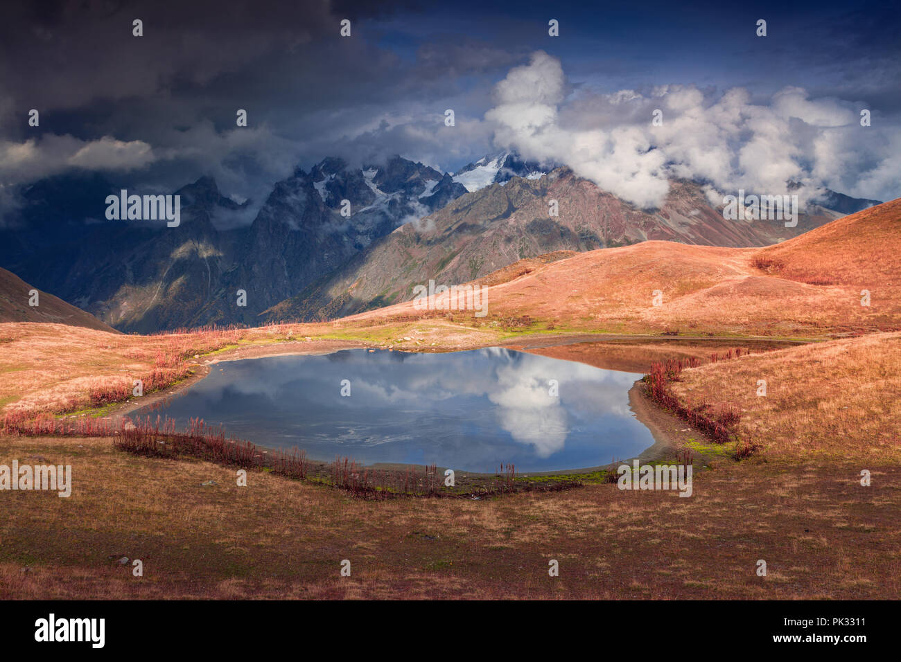 Colorful autumn morning on the lake Koruldi at the foot of Mt. Ushba. Upper Svaneti, Mestia, Georgia, Europe. Caucasus mountains. October 2015. Stock Photo