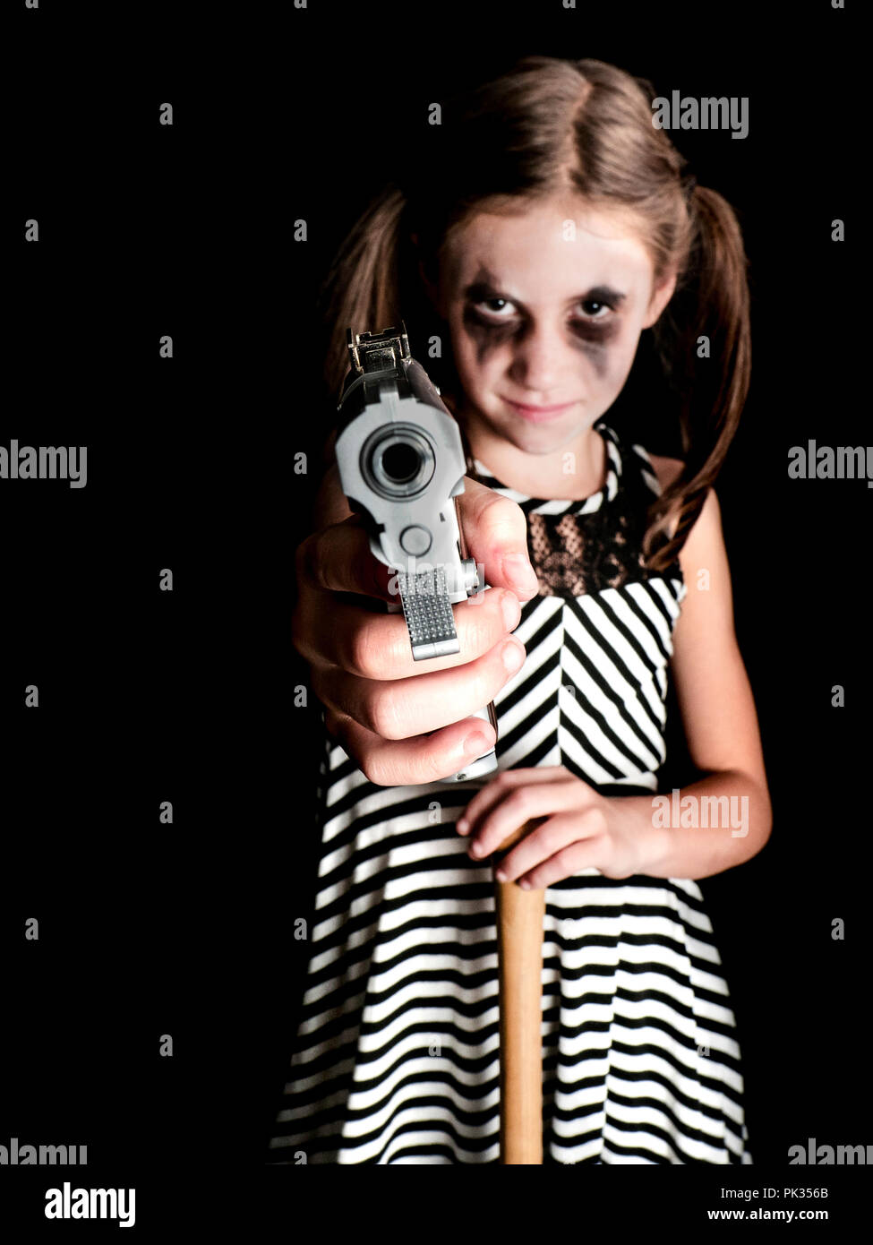 halloween children harley quinn harlequin, baseball bat and gun makeup little girl pigtails cosplay Stock Photo