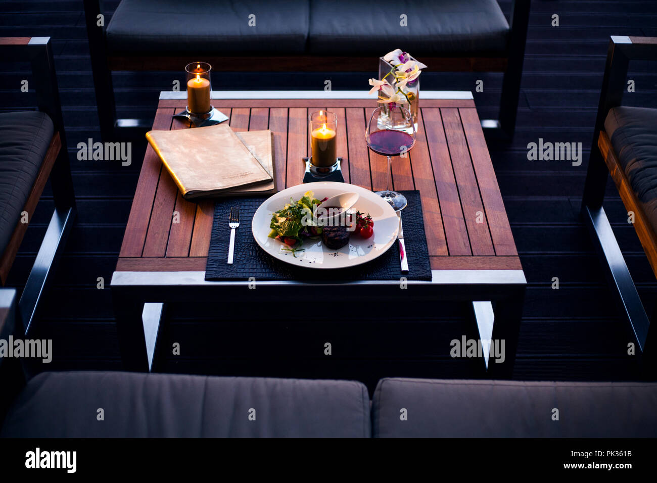 Table in restaurant served for one person and decorated with flowers and candles. Top view. Stock Photo