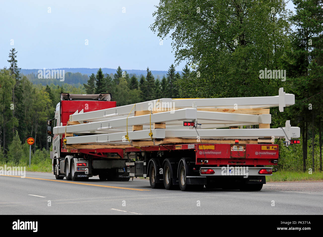 Scania R500 truck of Ismo Partanen for AT Special Transport hauls oversize industrial object on road, rear view. Ikaalinen, Finland - August 9, 2018. Stock Photo