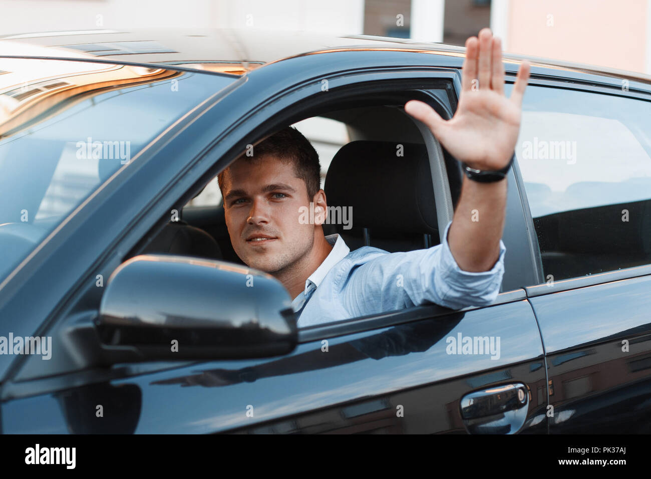 A young man in a car stuck his hand out the window. Man approves Stock Photo