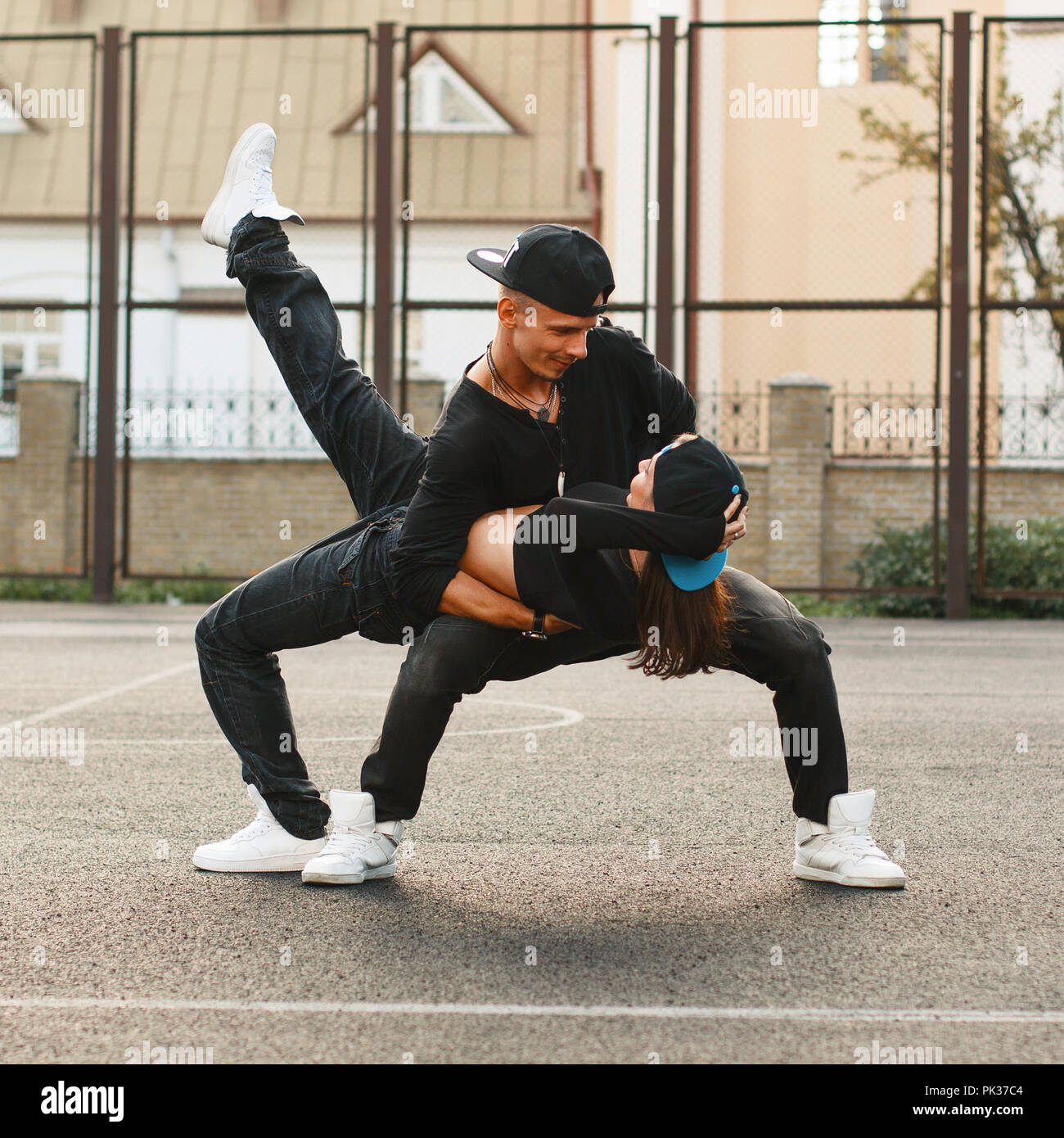 Beautiful young couple dancing hip-hop at the stadium. The guy holding the  girl in his arms Stock Photo - Alamy