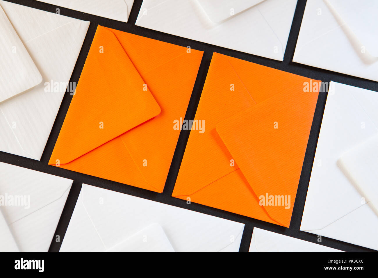Composition with white and orange envelopes on the table. Different colored envelopes on the table. Stock Photo