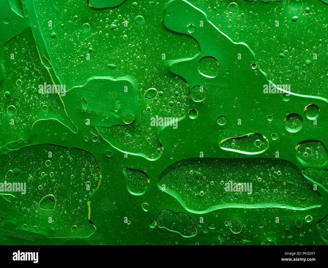 Bright green abstract background looks 3d. Strange texture with bubbles and holes. Immiscible liquids, unusual oil and water Stock Photo
