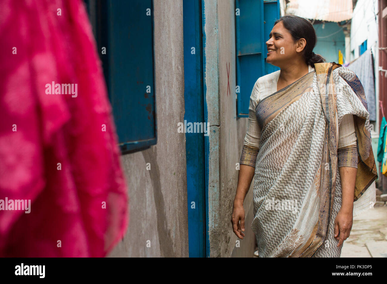 Woman visiting garment workers as part of community outreach work. Stock Photo