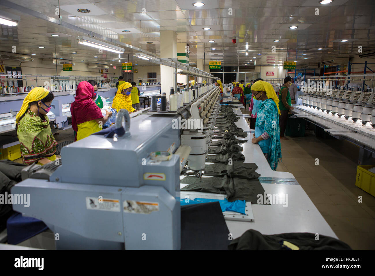Garment workers at work on sewing machines inside a garment factory in Bangladesh Stock Photo