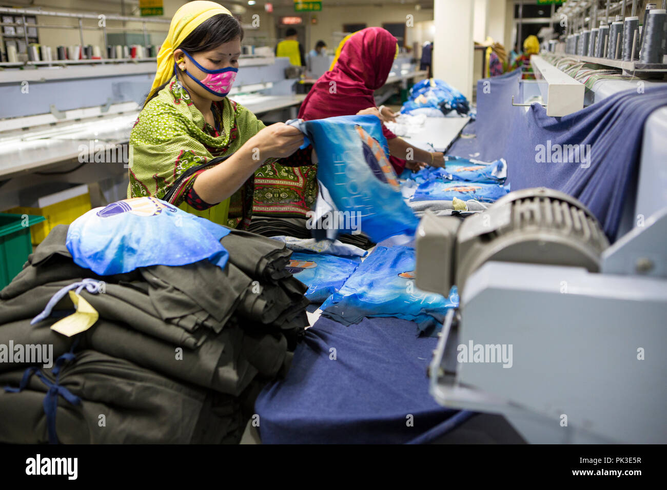Garment workers at work on sewing machines inside a garment factory in Bangladesh Stock Photo
