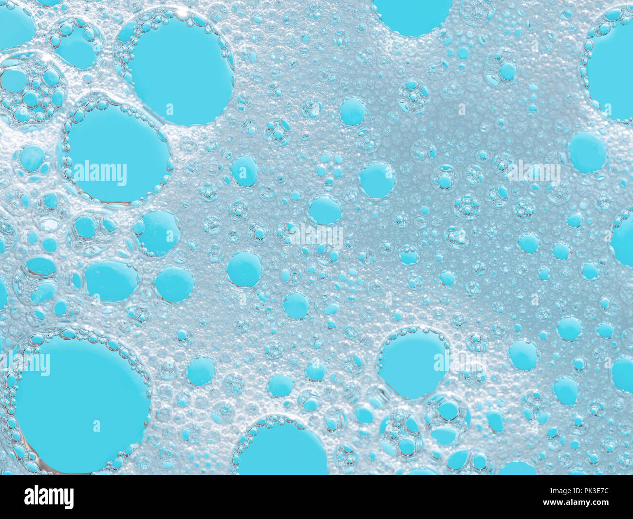 Turquoise froth, foamy background, soap, detergent bubbles on water. Stock Photo