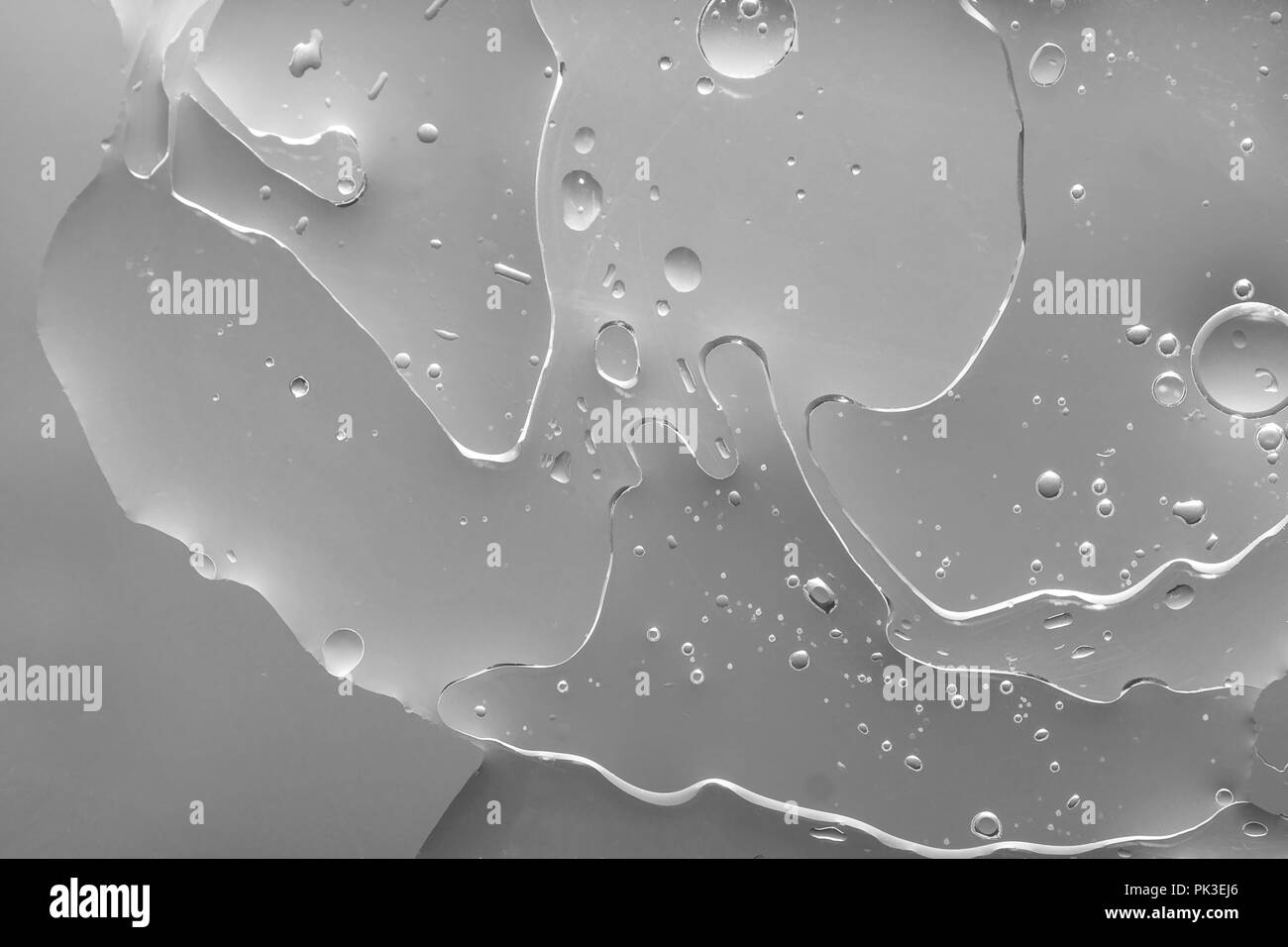 Silver grey abstract background looks 3d. Strangely sophisticated texture with organic bubbles and holes. Unusual oil and water. Stock Photo