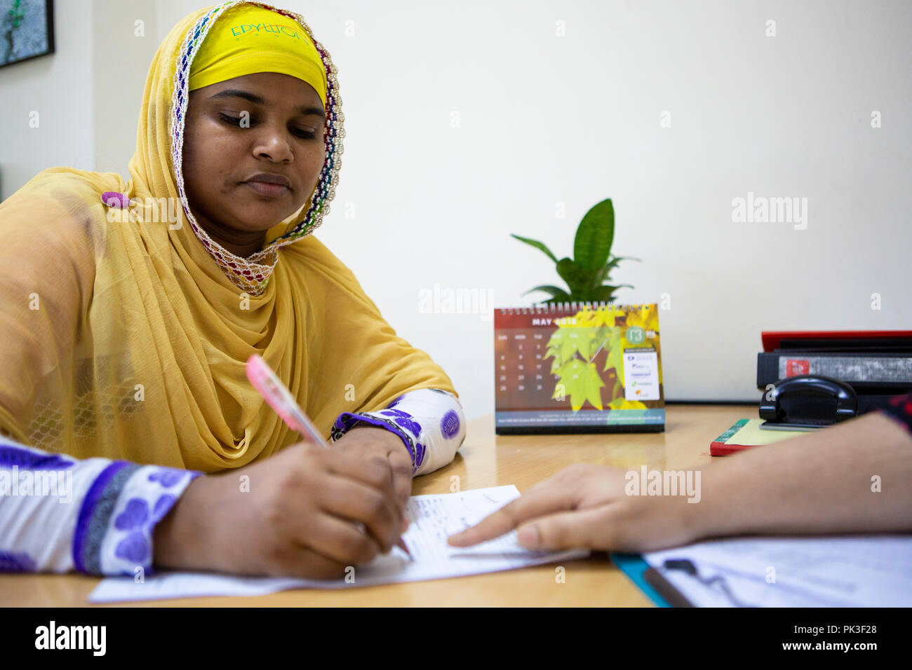 A female garment worker meeting with her manager in garment factory in Bangladesh. Stock Photo