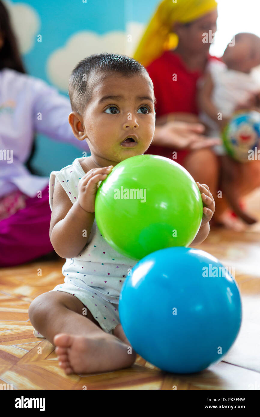 Young children playing in the child care centre in a garment factory in Dhaka, Bangladesh. Stock Photo