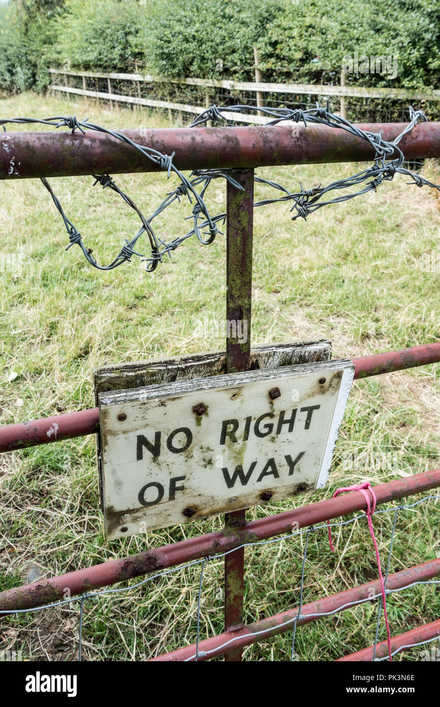 No right of way sign below barbed wire on farm gate in countryside