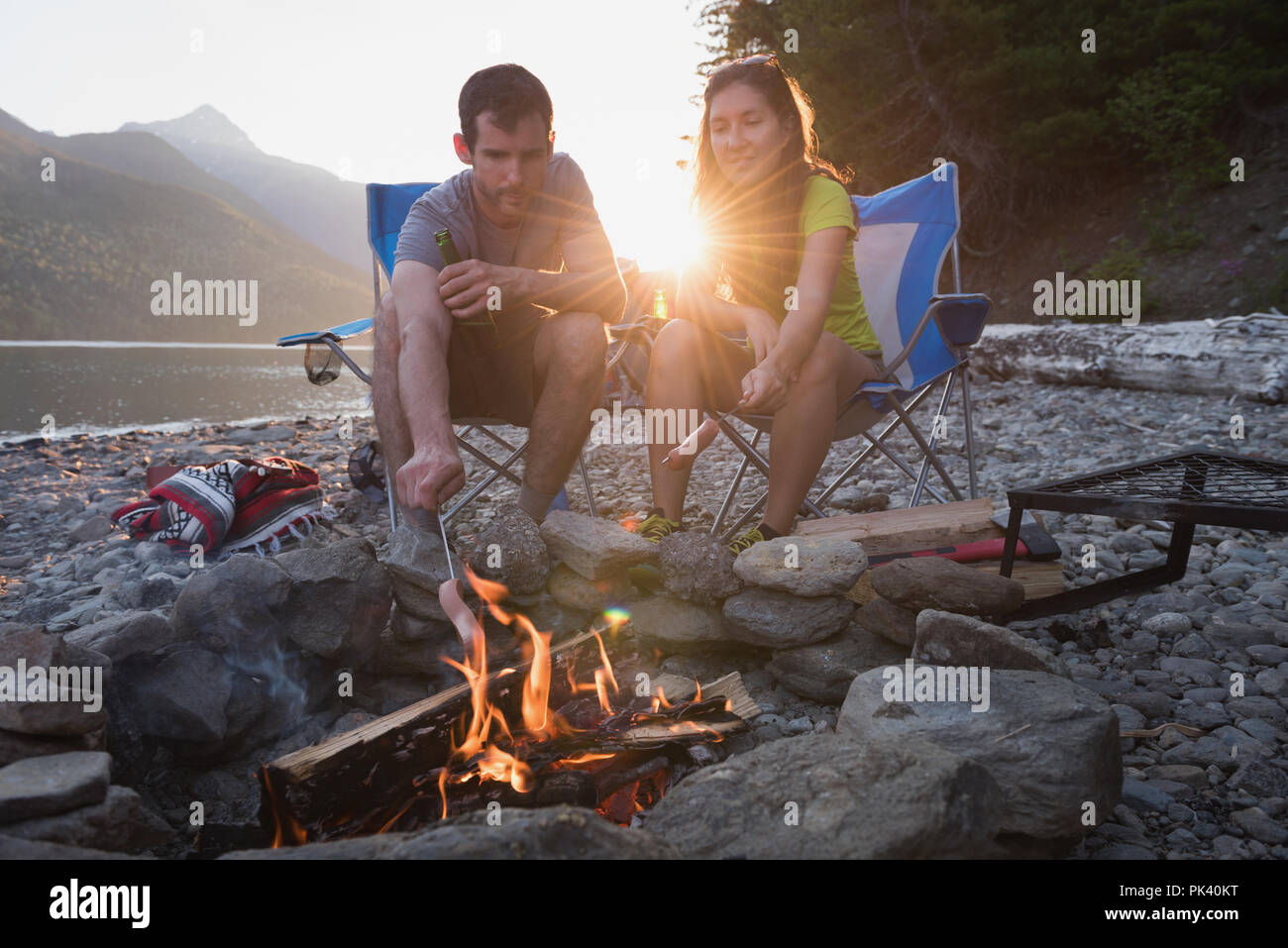 Couple roasting hot dog on campfire Stock Photo Alamy