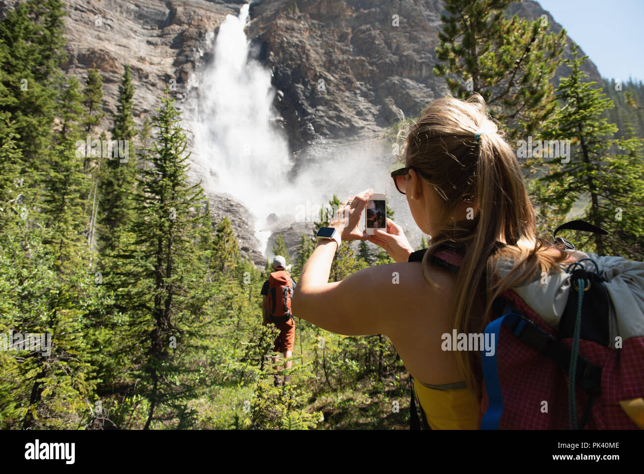 Female hiker clicking pictures with mobile phone Stock Photo