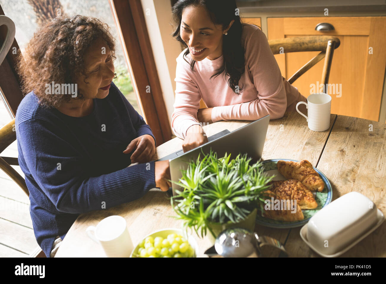 Mother and daughter discussing over laptop Stock Photo