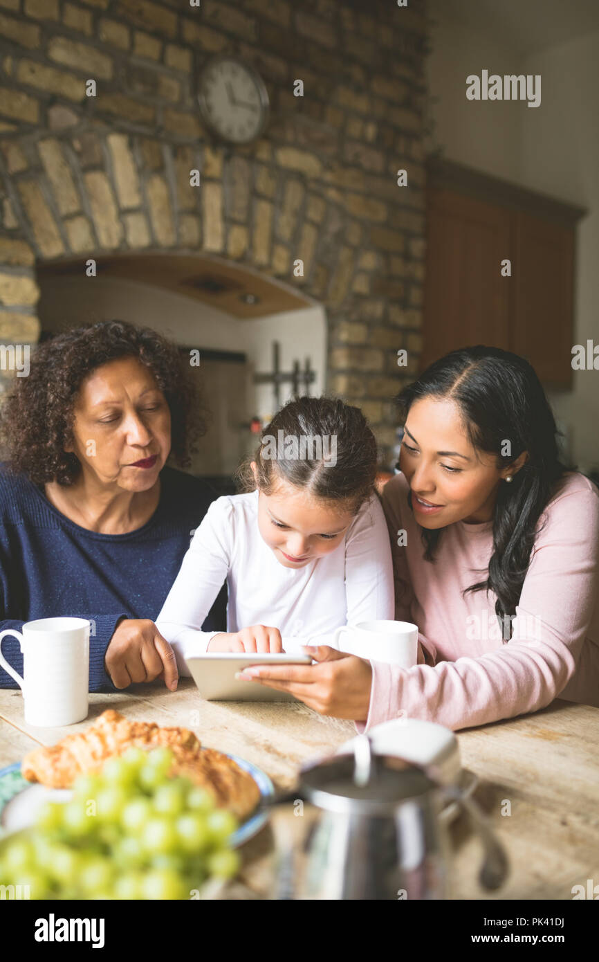 Family using digital tablet on dining table Stock Photo - Alamy