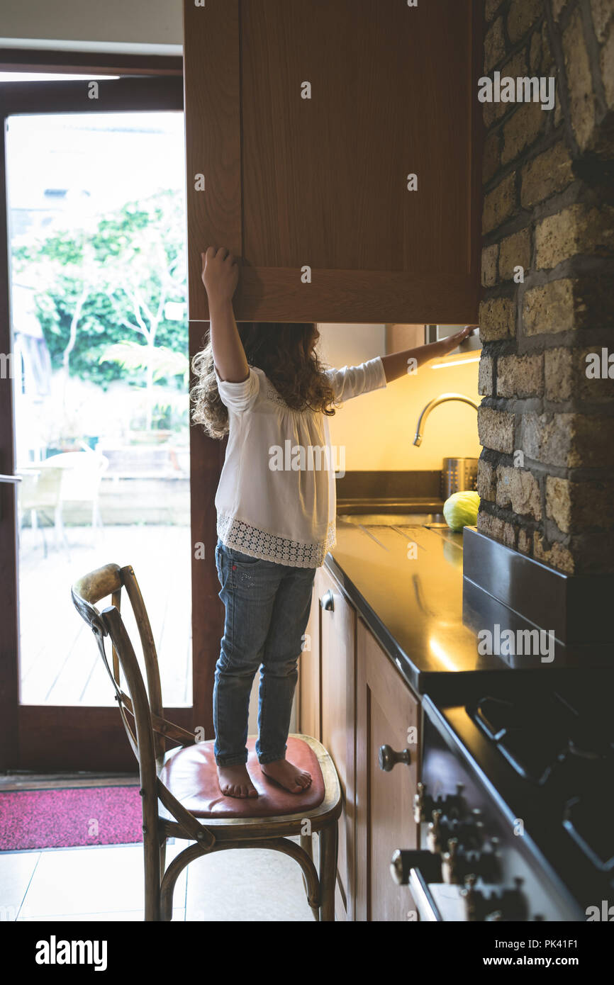 Girl searching for food in kitchen Stock Photo
