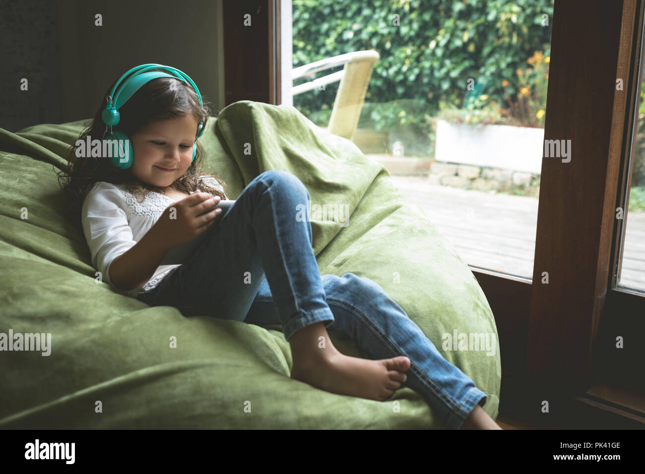 Girl listening music while using digital tablet Stock Photo