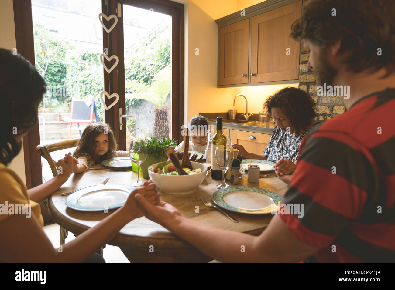 Family praying before having a meal Stock Photo