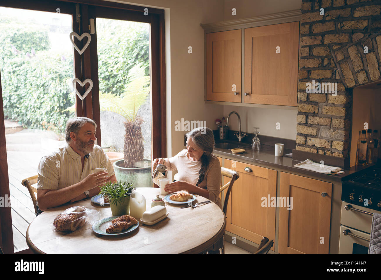 Senior couple having breakfast in kitchen Stock Photo