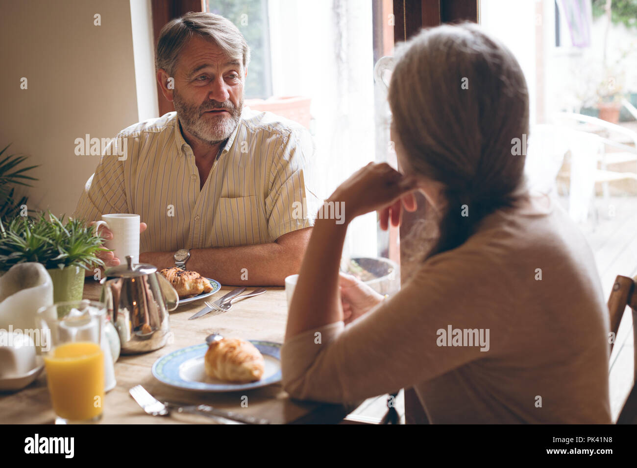 Senior couple interacting with each other while having breakfast Stock Photo