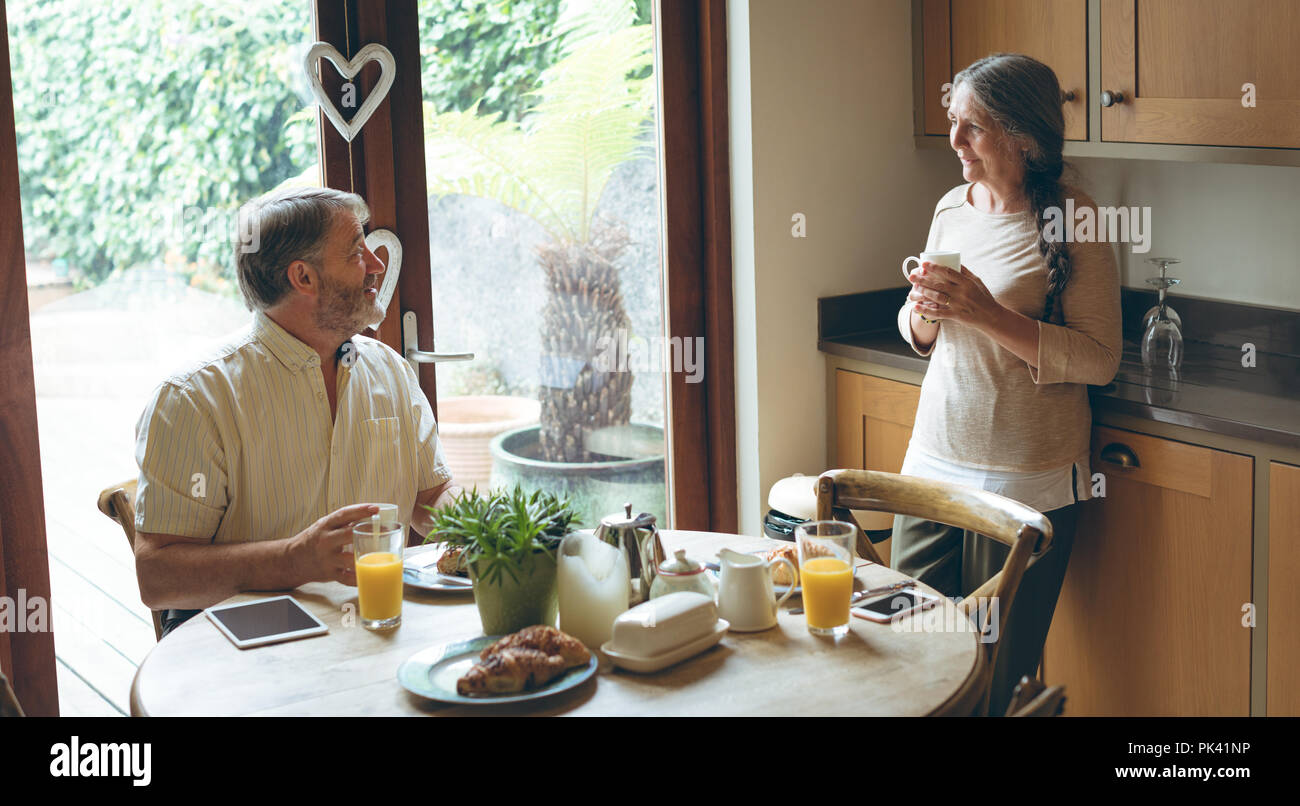 Senior couple interacting with each other while having breakfast Stock Photo