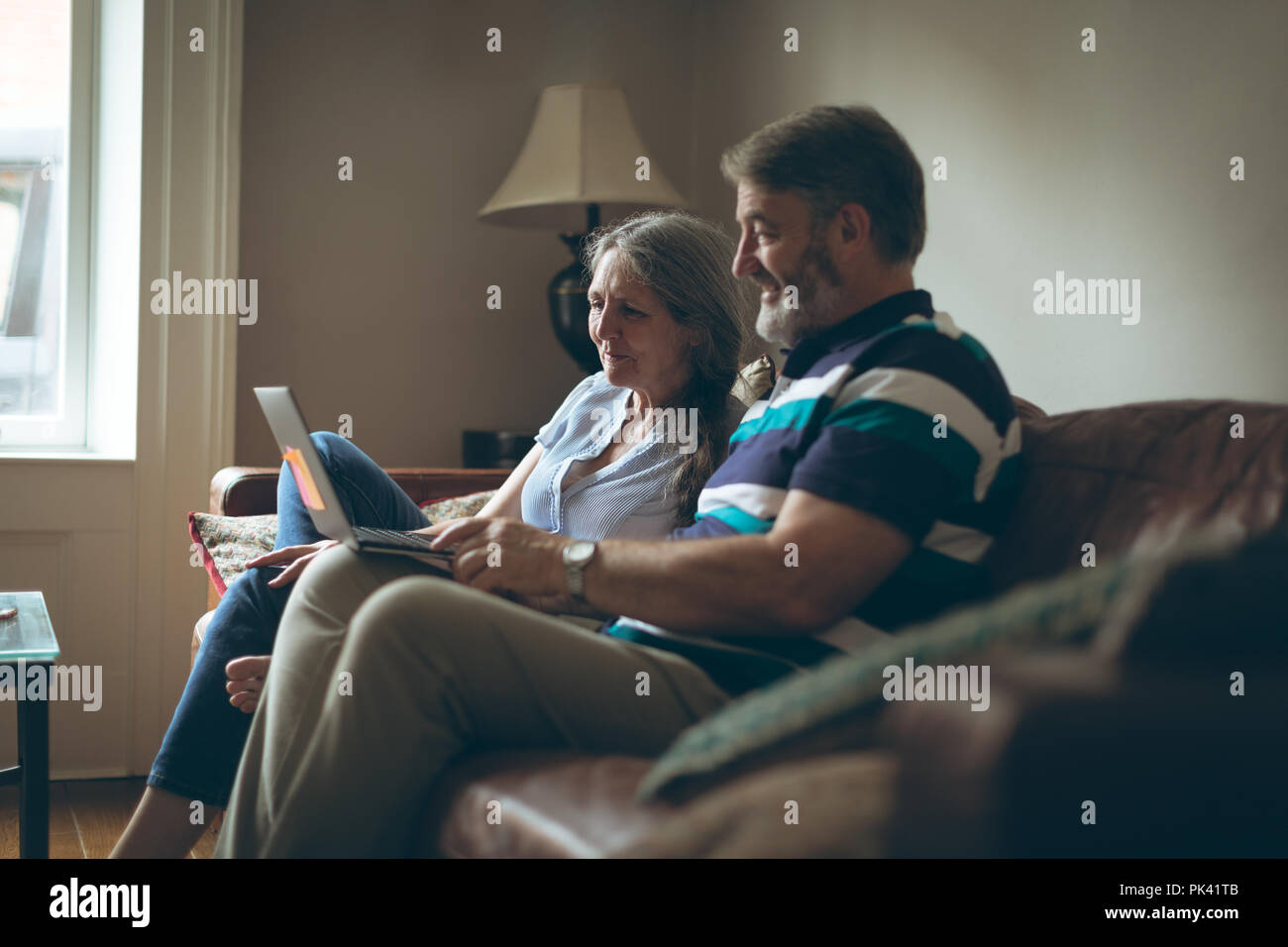 Senior couple using laptop in living room Stock Photo