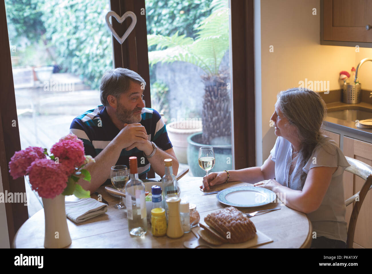 Senior couple interacting with each other on dining table Stock Photo