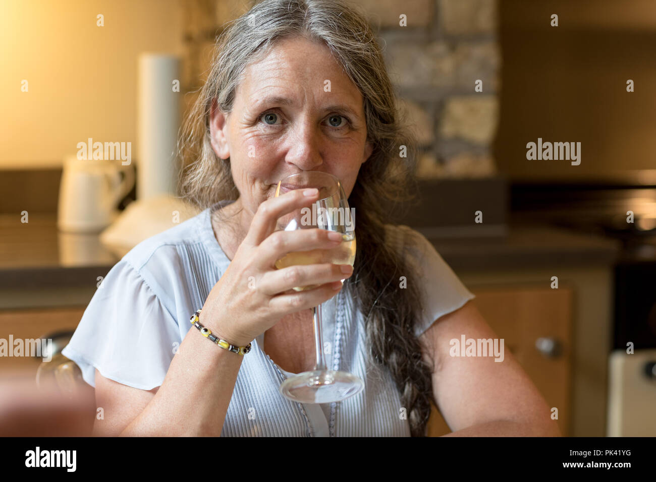 Senior woman having wine at home Stock Photo