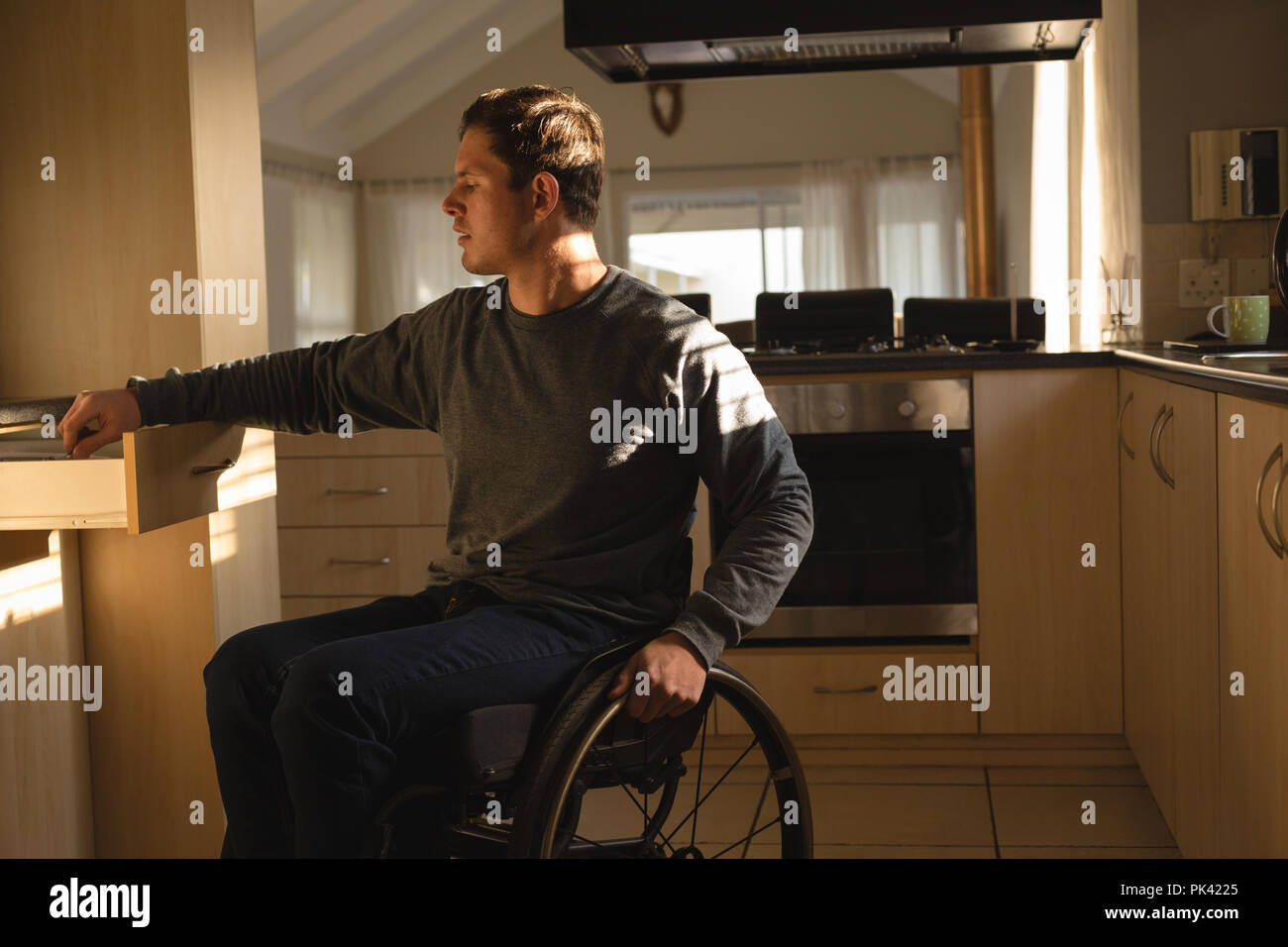 Disabled man removing utensil in kitchen Stock Photo