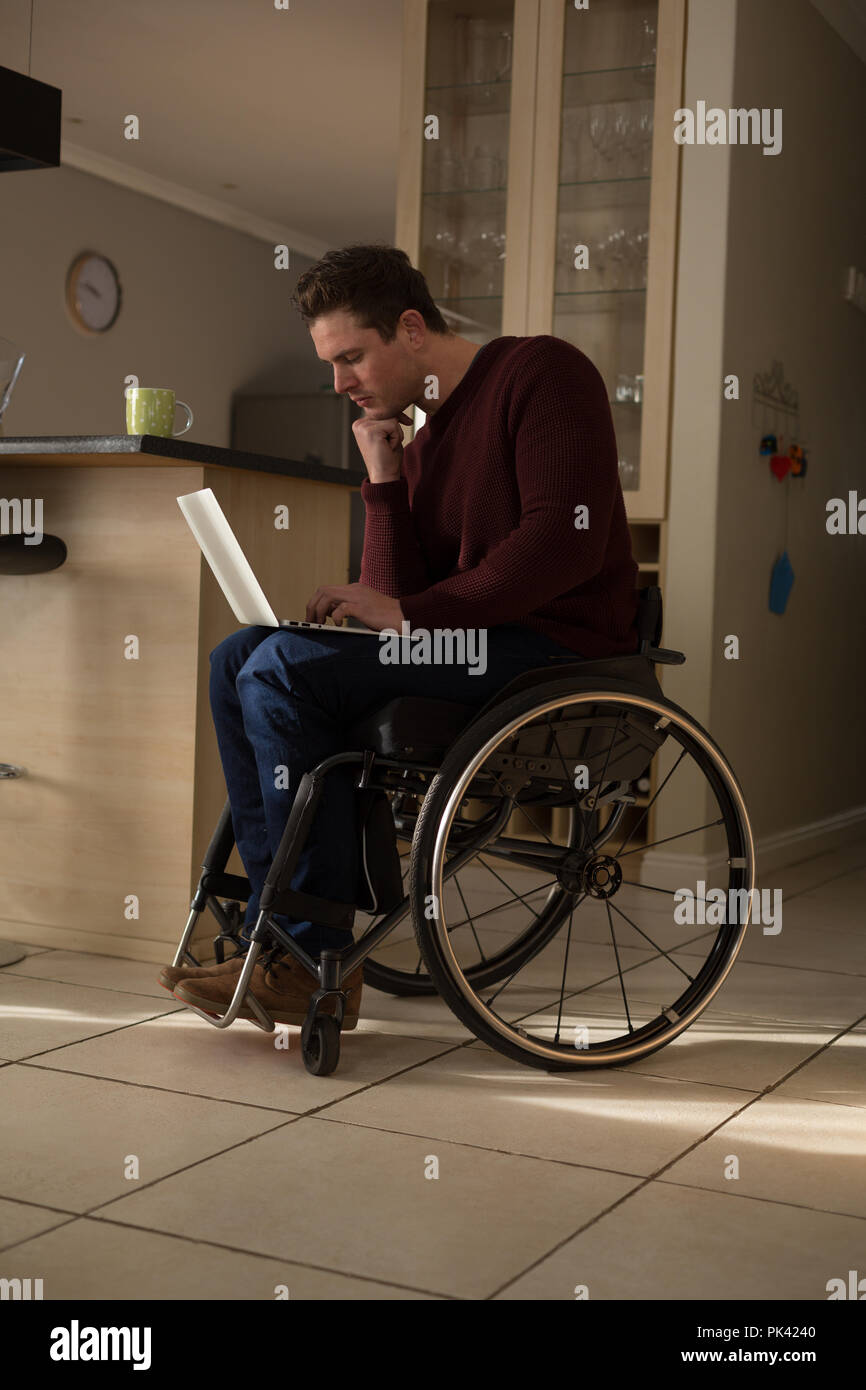 Disabled man using laptop at home Stock Photo