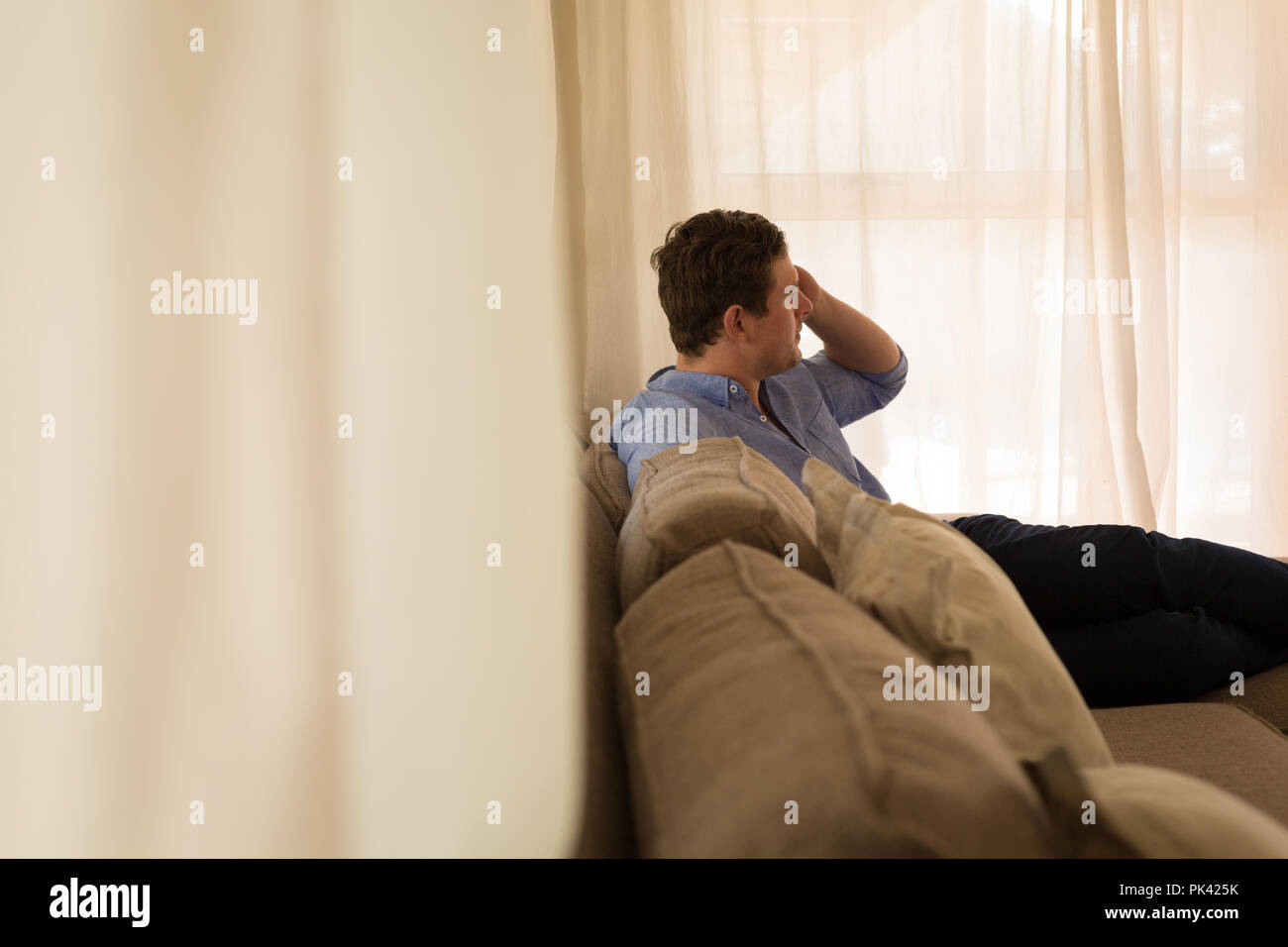 Disabled man talking on mobile phone in living room Stock Photo
