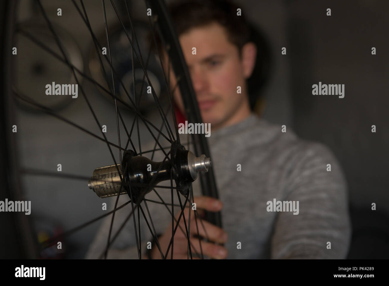 Disabled man repairing wheelchair at workshop Stock Photo