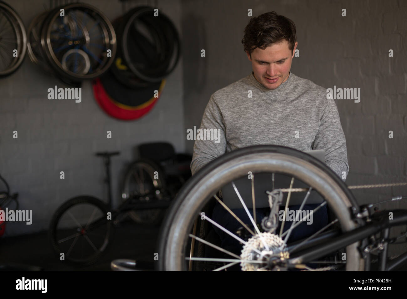 Disabled man repairing wheelchair at workshop Stock Photo